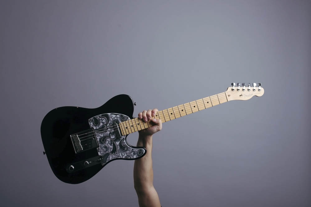 image of a black music man guitar on grey background